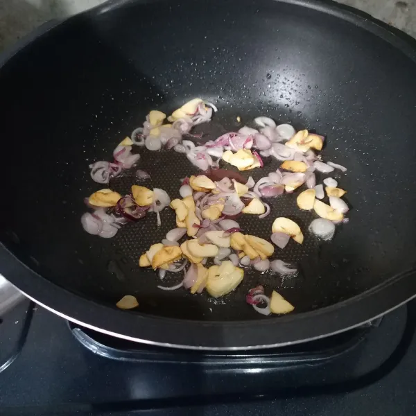 Tumis irisan bawang merah dan bawang putih sampai harum.