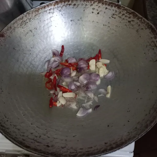 Tumis irisan bawang merah, bawang putih dan cabe merah keriting hingga harum.