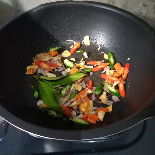 Masukkan irisan cabai, lengkuas dan daun salam. Tumis lagi sampai layu.