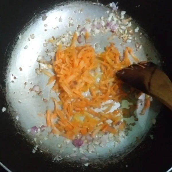 Tumis bawang putih, bawang merah cincang hingga harum, lalu masukkan serutan wortel, tumis hingga layu