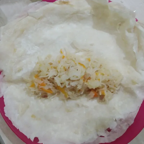 Siapkan lembaran kulit lumpia siap pakai, lalu ambil secukupnya bihun goreng, letakkan diatas kulit lumpia, lalu lipat dan gulung, padatkan pelan pelan, untuk ujung agar bisa merekat, oleskan putih telur atau air