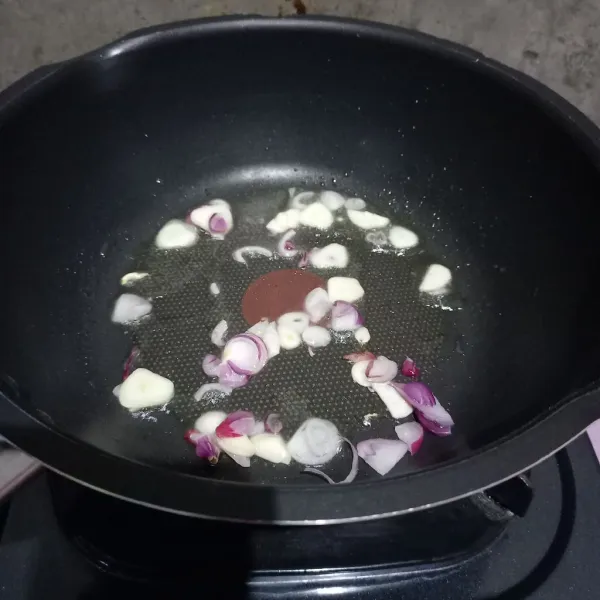 Tumis irisan bawang merah dan bawang putih sampai layu.