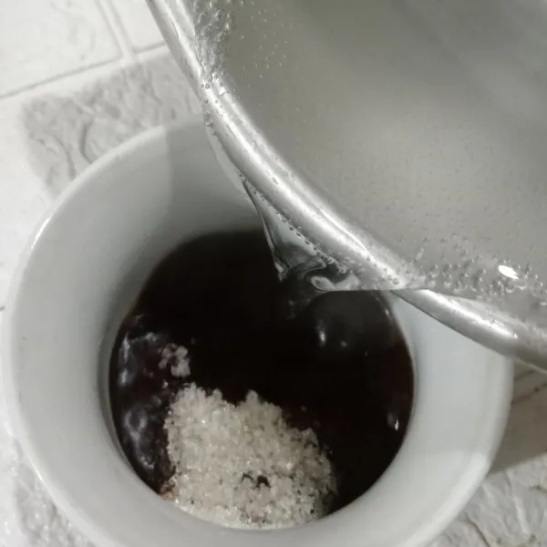 Tuang air dalam cangkir berisi kopi
