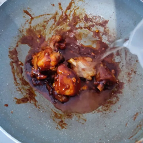 Kemudian masukkan ayam yang sudah digoreng, aduk rata dengan bumbu. Lalu tambahkan air, masak sampai air menyusut.