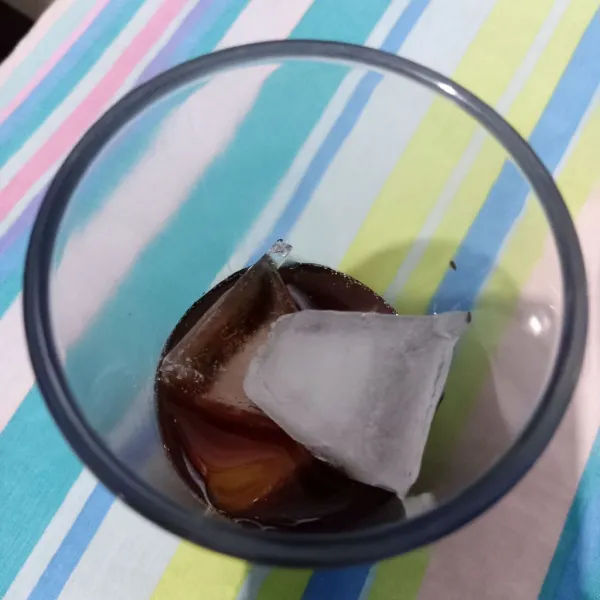 Masukkan gula dalam gelas, lalu beri es batu.