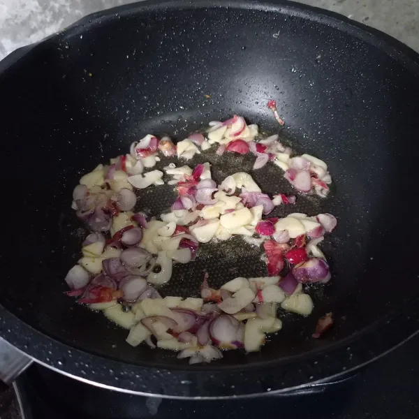 Tumis irisan bawang merah dan bawang putih sampai harum.