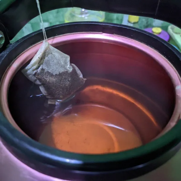 Masak air bersama gula pasir di dalam teko, kemudian matikan api saat mendidih. Celup perlahan teh hingga warnanya berubah.