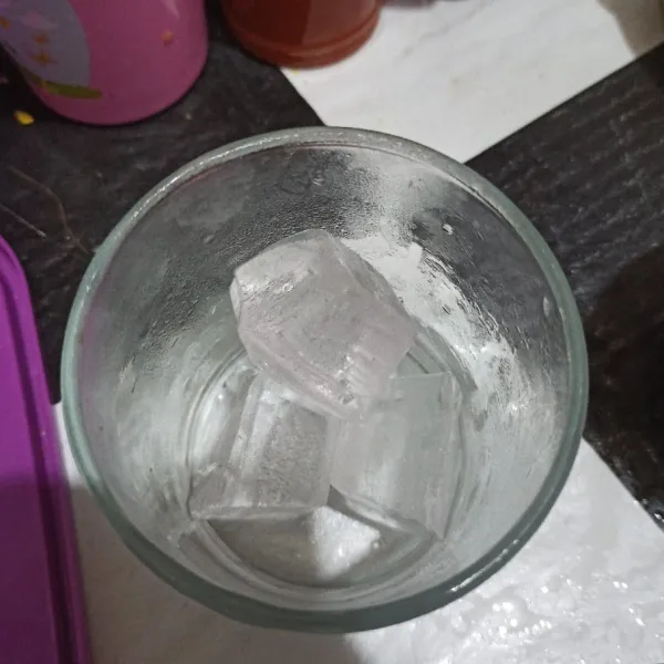 Masukkan es batu ke dalam gelas saji.