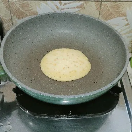Panaskan teflon, olesi dengan minyak goreng. Ambil 1 sendok sayur adonan, tuang dalam teflon. Biarkan sampai adonan berlubang.