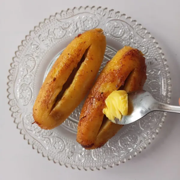 Selagi masih panas, beri secukupnya margarin dan kental manis ke dalam pisang, biarkan meleleh.