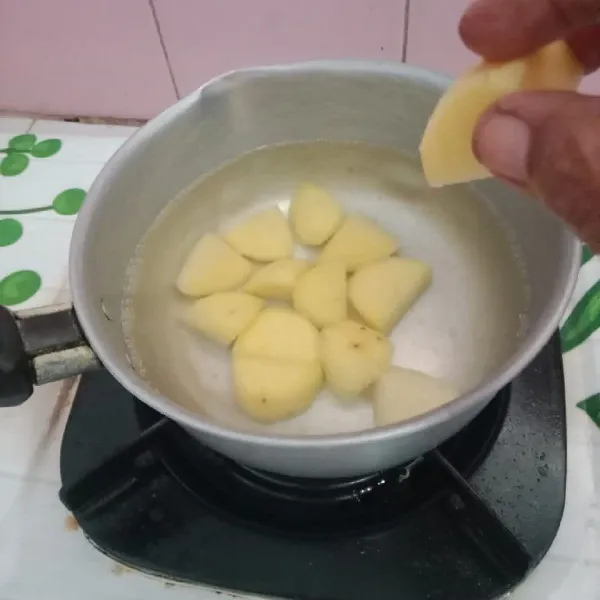 Kupas kulit kentang, potong-potong dan cuci bersih, kemudian rebus sampai matang.
