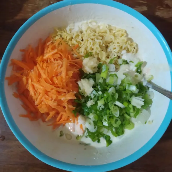 Masukkan wortel yang diparut kasar, irisan daun bawang prei, mie dan bawang putih halus. Aduk rata.