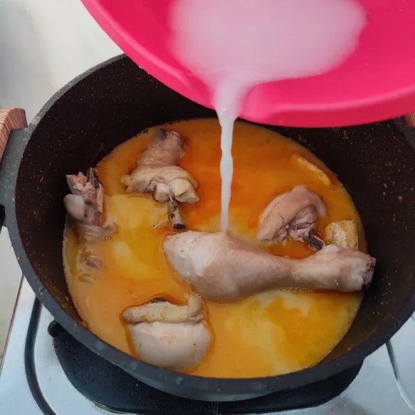 Masukkan ayam rebus dan tahu goreng, tambahkan santan encer. Rebus dengan api kecil sampai ayam empuk.