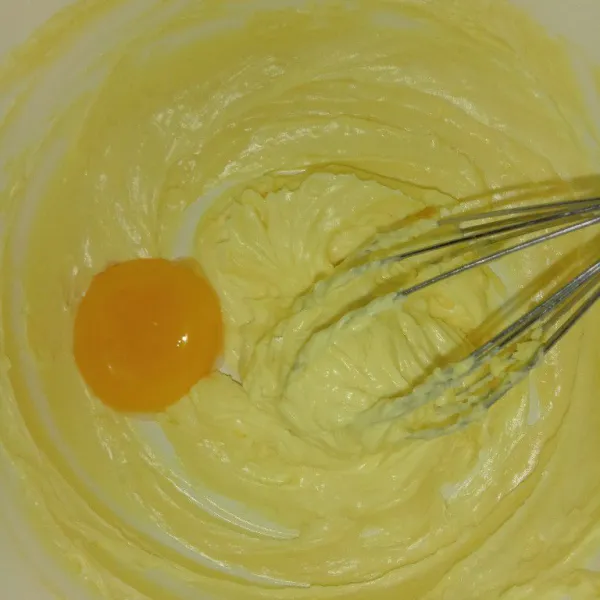 Tambahkan kuning telur aduk rata, kemudian tambahkan susu bubuk dan tepung maizena aduk rata.