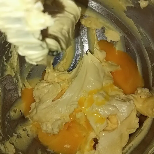 Mixer gula halus butter dan margarin hingga mengembang selama 2 menit lalu masukkan kuning telur. Mixer kembali hingga tercampur rata saja.