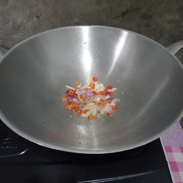 Tumis irisan cabai dan bawang sampai layu.