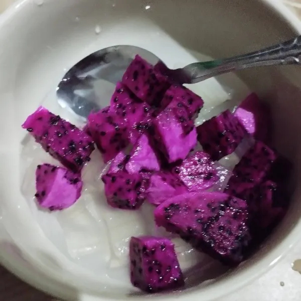 Tambahkan potongan buah naga, lalu es batu.