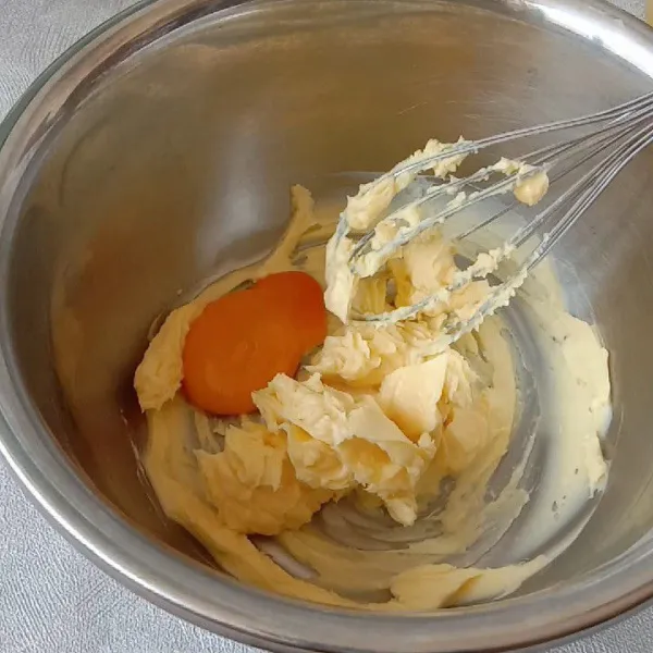 Mix gula dan margarin sampai tercampur saja. Lalu masukkan kuning telur. Mix hingga tercampur rata sekitar 1-2 menit. Bagi adonan menjadi 2 bagian