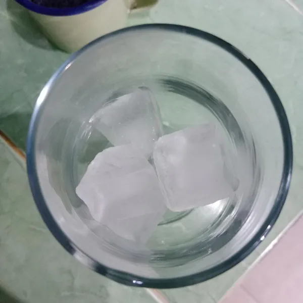 Masukkan es batu ke dalam gelas.