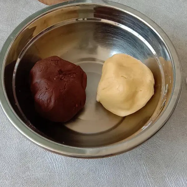 Aduk adonan margarine dengan campuran tepung satu bagian biarkan original dan satu bagian lagi tambahkan coklat bubuk/pasta coklat
