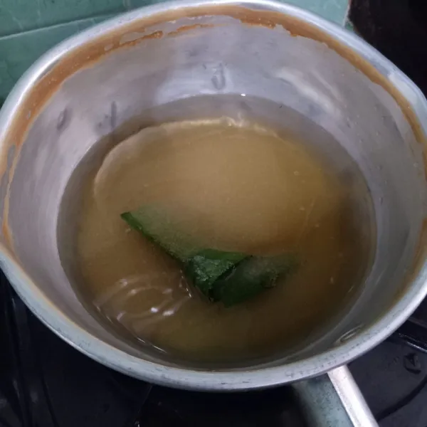 Masukkan gula dan daun pandan di panci. Tuangi air. Rebus hingga mendidih.