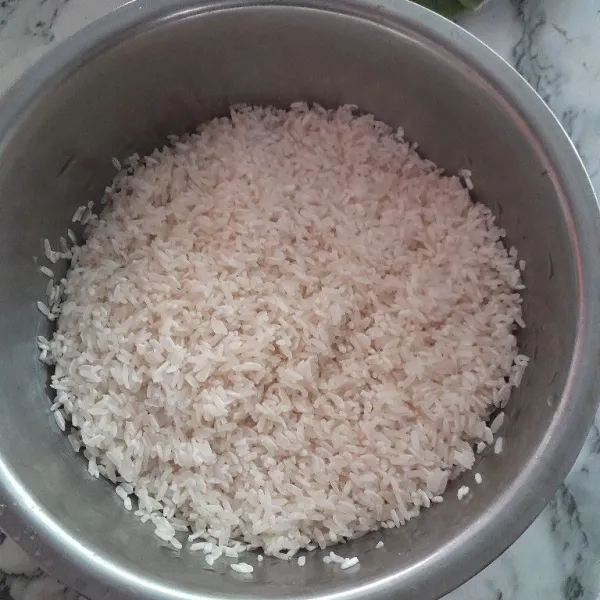 Cuci beras seperti pada umumnya, beri sedikit garam, aduk rata.