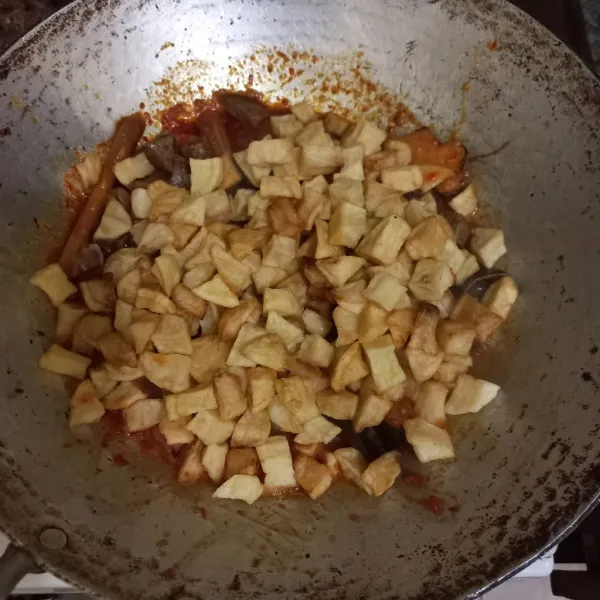 Masukkan kentang goreng, masak hingga bumbu menyerap.