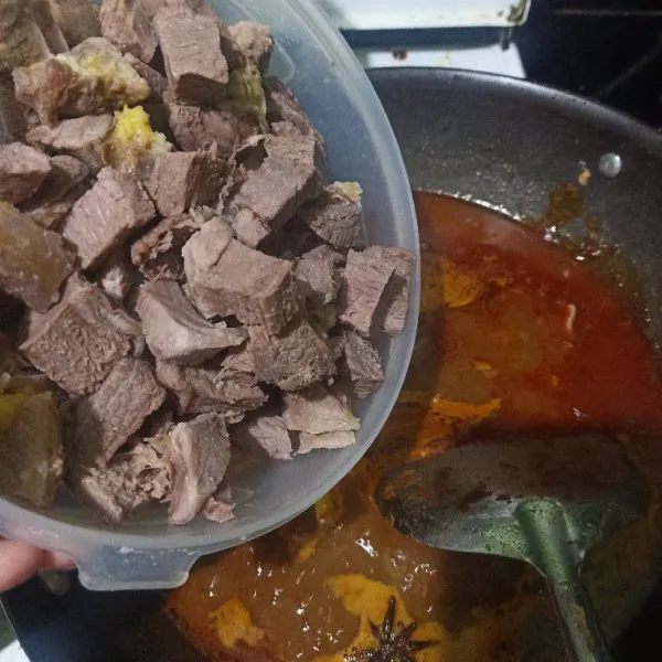 Masukkan santan instan dan santan kental ke dalam wajan berbumbu. Aduk rata, lalu masukkan potongan daging.