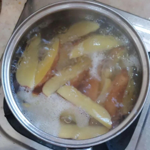 Cuci bersih kentang belah 8, lalu rebus sebentar, jangan sampai terlalu lembut. Tiriskan.