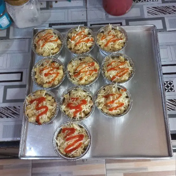 Taruh makaroni ke alumunium cup lalu beri saus tomat.