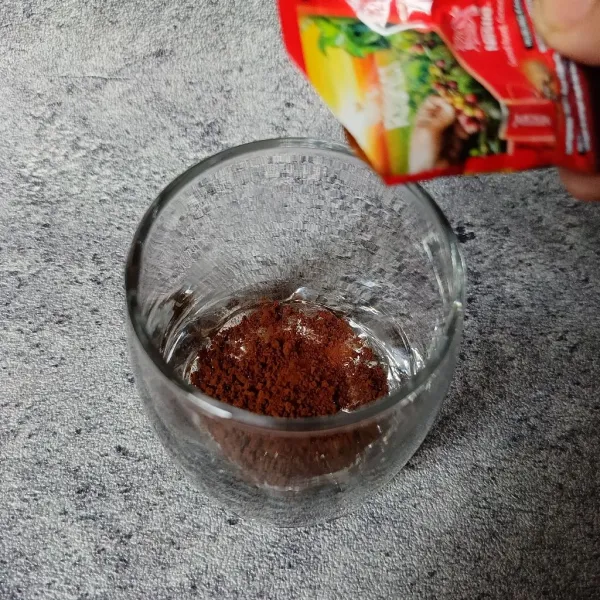 Masukkan kopi bubuk ke dalam gelas.