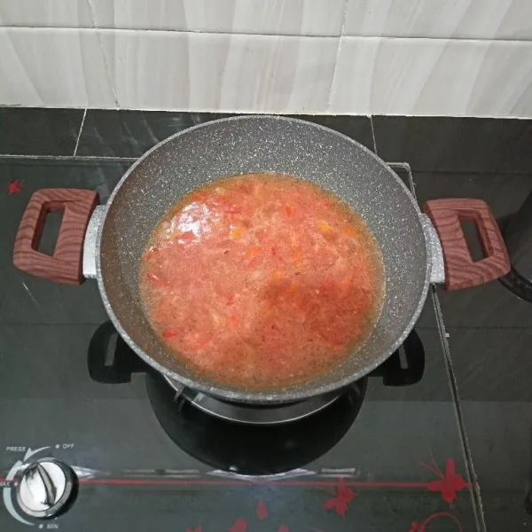 Lalu masukkan tomat halus, air, gula aren, kaldu bubuk dan garam. Masak hingga mendidih.