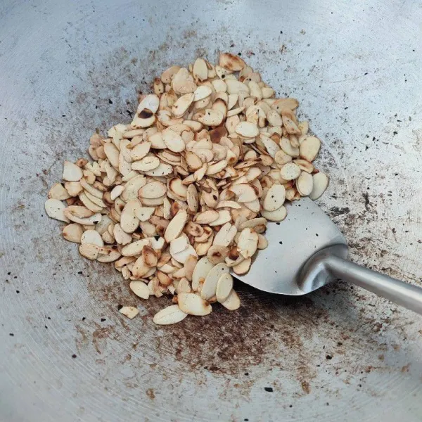Di wajan yang sama, sangrai kacang almond slice yang sudah dicuci hingga matang dan biarkan dingin.