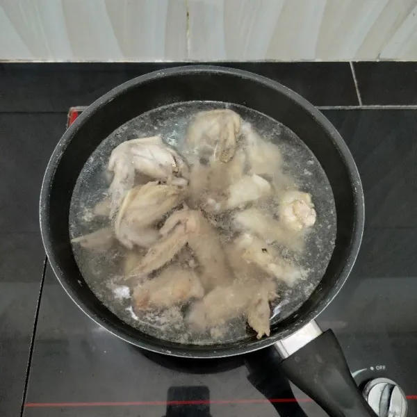 Rebus sayap ayam dengan air hingga mendidih. Tiriskan ayam dan buang air rebusannya.