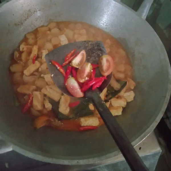 Masuk irisan tomat, cabe rawit utuh, dan santan. Lalu, koreksi rasanya.