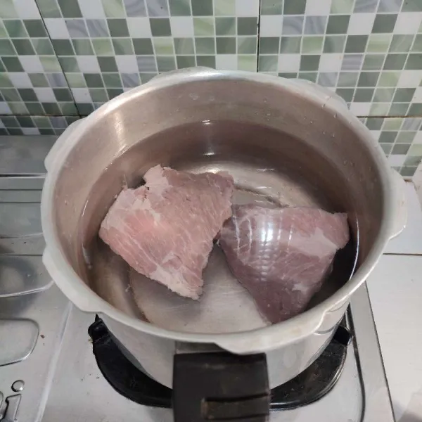 Didihkan air, kemudian masukkan daging, tutup dan rebus selama 10 menit. Matikan api. Lalu diamkan 30 menit. Setelah itu rebus kembali daging selama 7 menit sambil di tutup. Buang busanya jika ada.