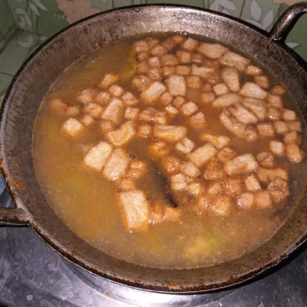 Masukkan kikil dan tahu. Tambahkan air, masak hingga mendidih.