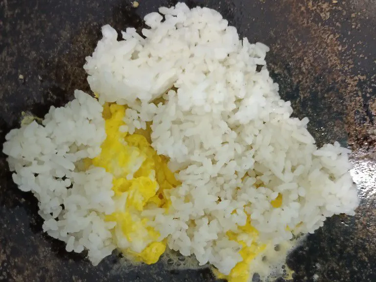 Masukkan nasi putih. Aduk rata. Taburi garam.