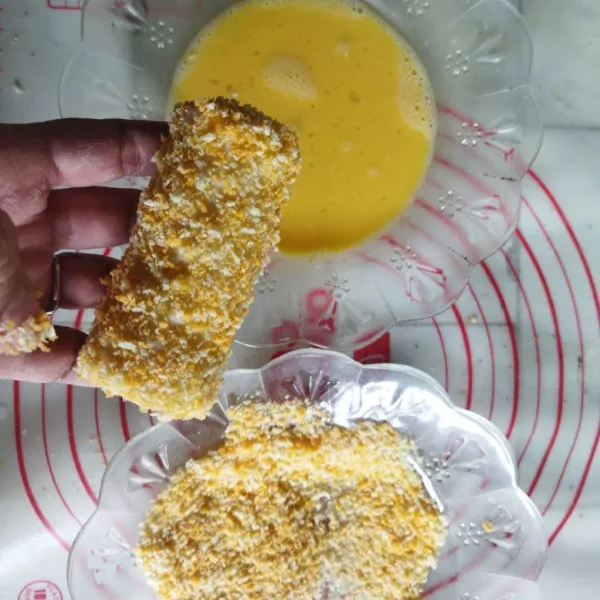 Lumuri risol dengan campuran telur dan susu, lalu gulingkan pada tepung panir. Lakukan sebanyak 2x.