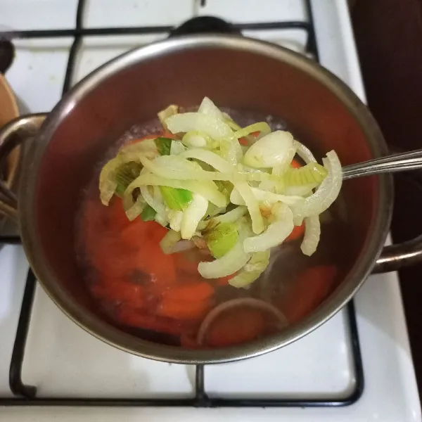 Masukkan tumisan bawang ke dalam panci rebusan.