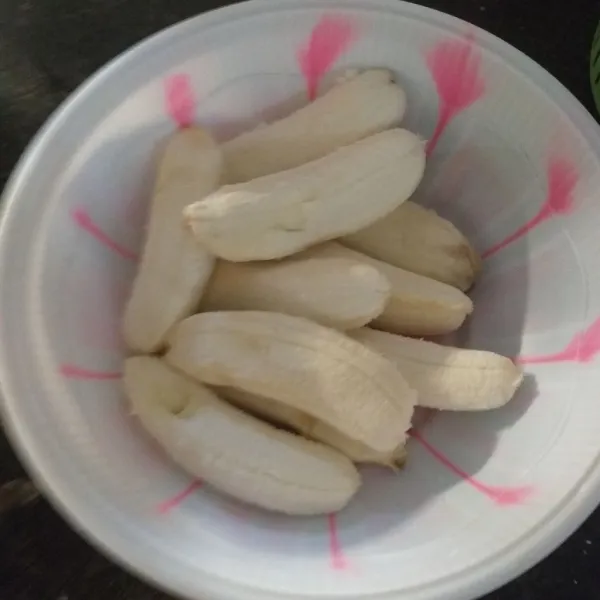 Kupas pisang kemudian belah menjadi dua bagian tidak putus.
