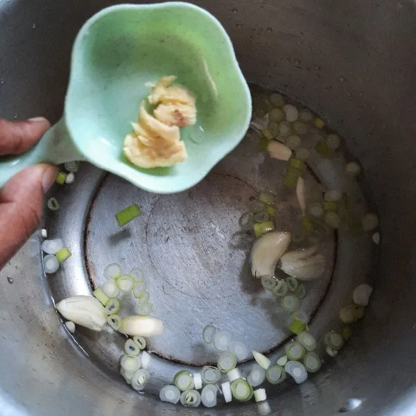 Masukkan air, bawang putih, jahe dan daun bawang ke dalam panci presto.