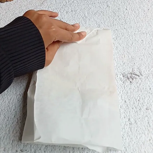Ambil kertas roti, lalu bungkus sandwichnya.