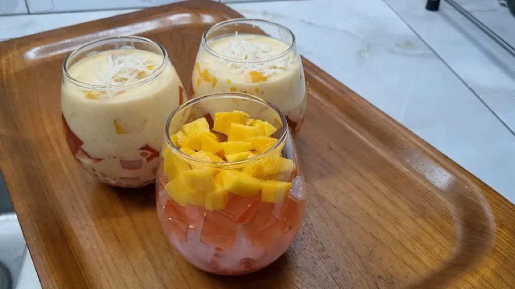 Susun isian buko mangga: Mutiara sagu, jelly mangga, nata de coco, dan toppingnya boleh ditambahkan lagi dengan potongan mangga.