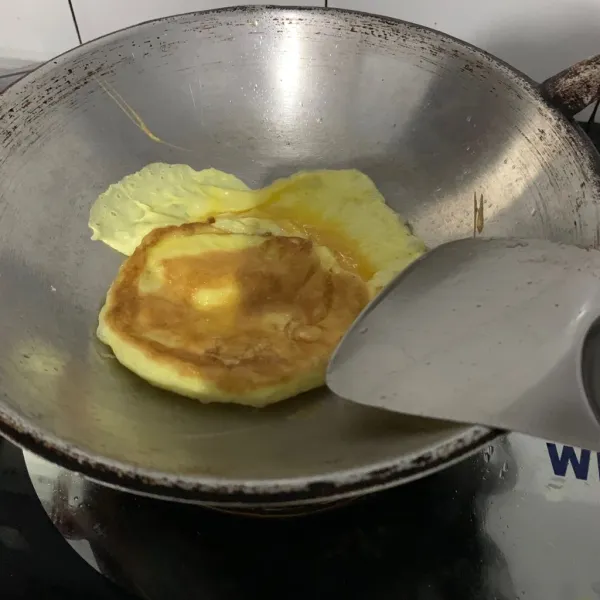 Goreng telur untuk toping.