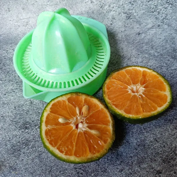 Belah dua jeruk dan peras ambil airnya.