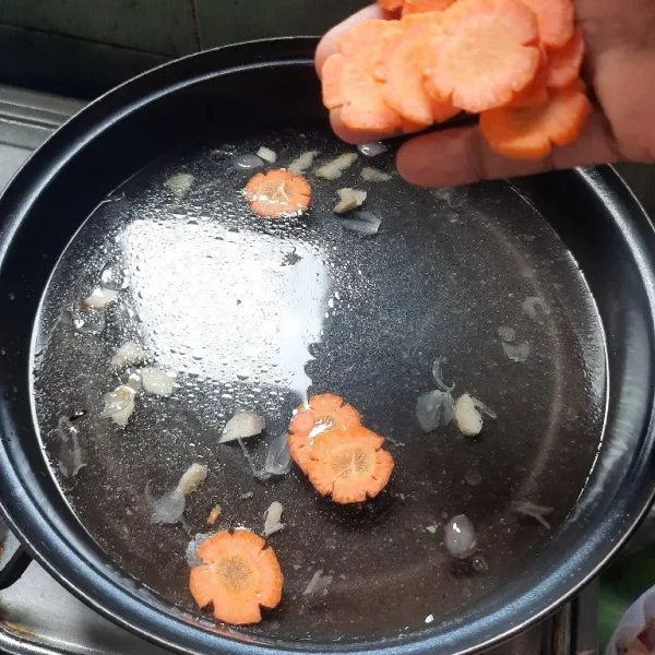 Masukkan air dan wortel, rebus sampai wortel setengah matang.