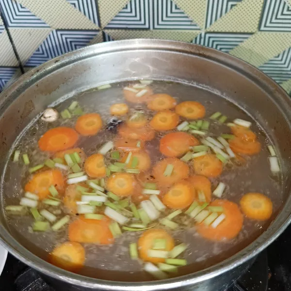 Angkat ayam dari panci, lalu tambahkan irisan daun bawang, garam, gula pasir dan kaldu jamur. Aduk-aduk dan koreksi rasanya, matikan kompor.