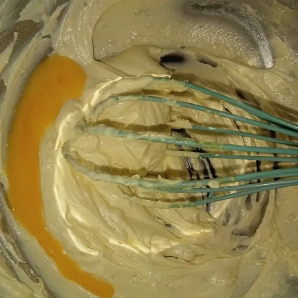 Aduk gula halus dan butter hingga mengembang kurang lebih 2 menit menggunakan whisk. Masukkan kuning telur aduk rata.