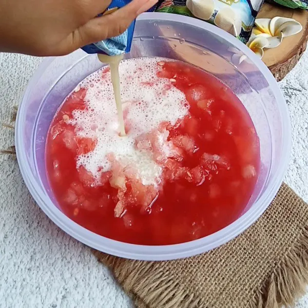 Campurkan blenderan es krim mochi dalam wadah semangka. Tambahkan kental manis.